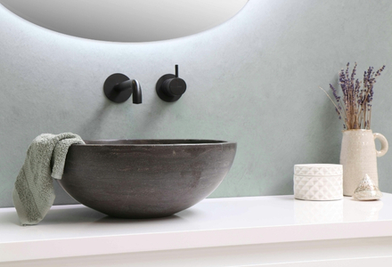 black surface mounted stone sink with black taps